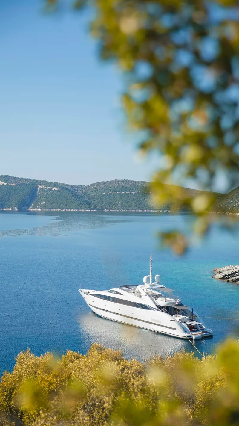 Yacht at anchor in a turquoise cove